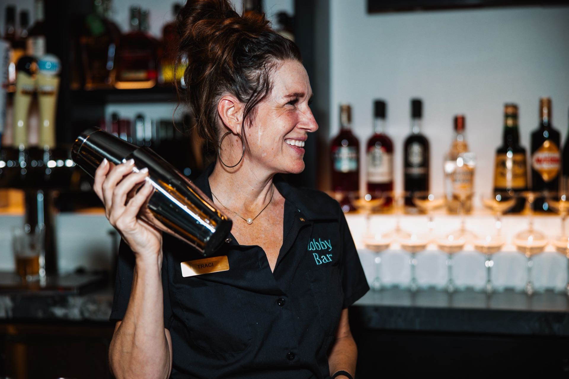 A bartender mixing a drink behind the Lobby Bar at the Radisson Plaza Hotel
